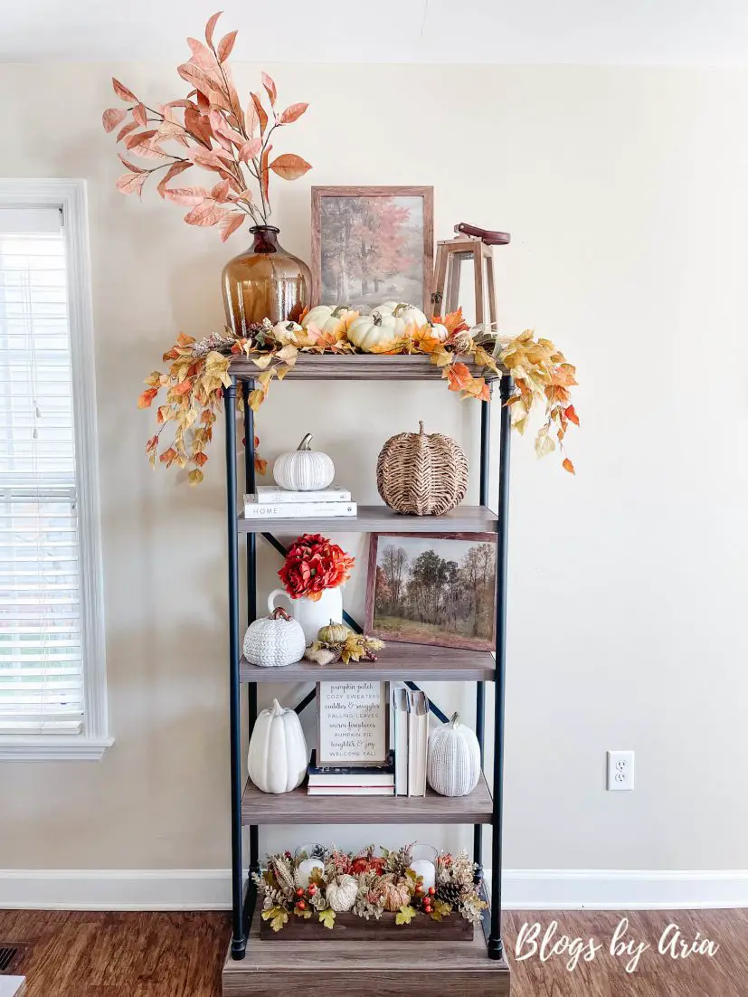 Fall styled bookshelf with pumpkins, autumn art and fall florals