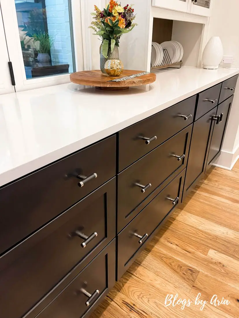 kitchen island with black cabinets and white quartz countertops