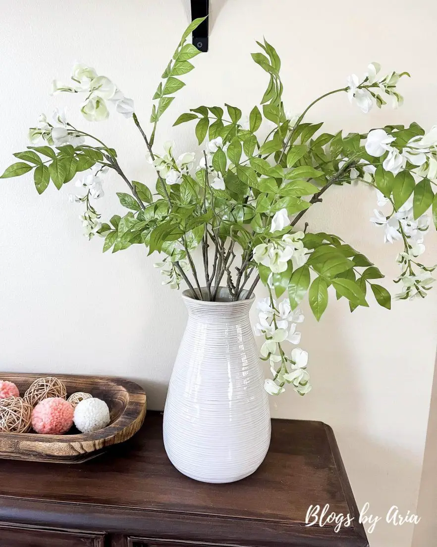 artisan glass vase styled with wisteria stems
