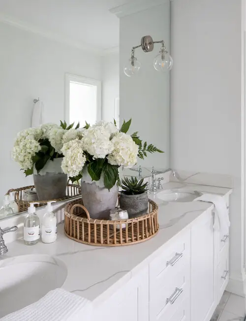 bathroom decorating idea with round woven tray and flowers in vase